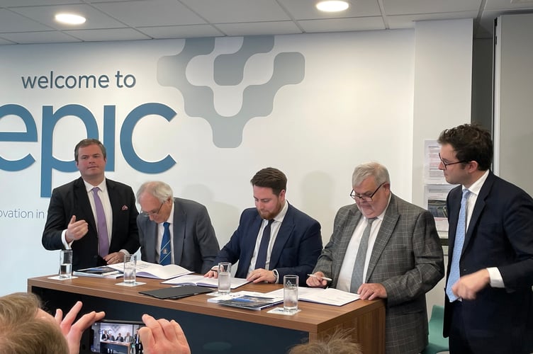 Council leaders, Cllr John Hart, Cllr David Thomas and Minister for Levelling Up Luke Young MP signing the Devon and Torbay devolution deal