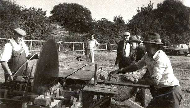 Men operating a rack saw.
A tree is being rolled on to the rack saw bench. Wally ? Is on the left and David Mortimore on the right.
