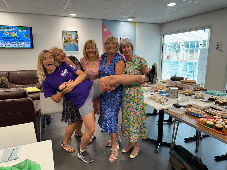 Ms Chapman being carried by some of her fundraising team members at a recent coffee morning at the Ivybridge Leisure Centre