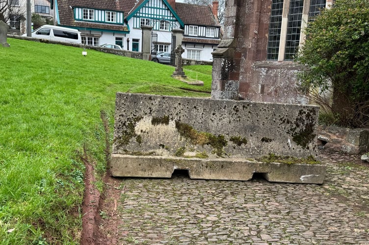 The barrier placed across a pathway at Crediton Parish Church and tyre tracks alongside.  AQ 2481
