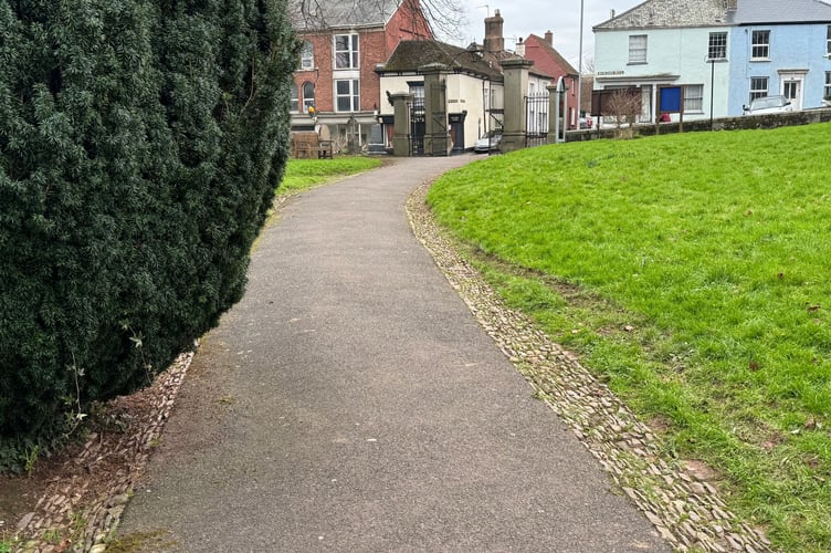 Tyre tracks on the verge of the church pathway and the gate in the distance which it is believed was used to gain access and to leave.  AQ 2488
