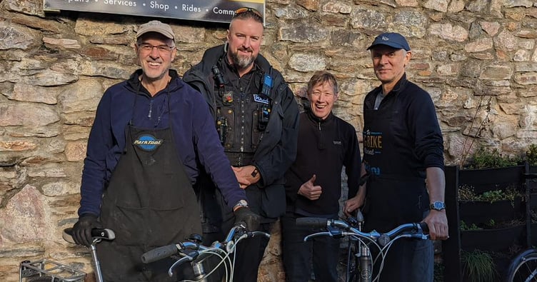 PC Barnaby Geary, who applied for POCA funds, with volunteers at the Totnes Bike Hub.