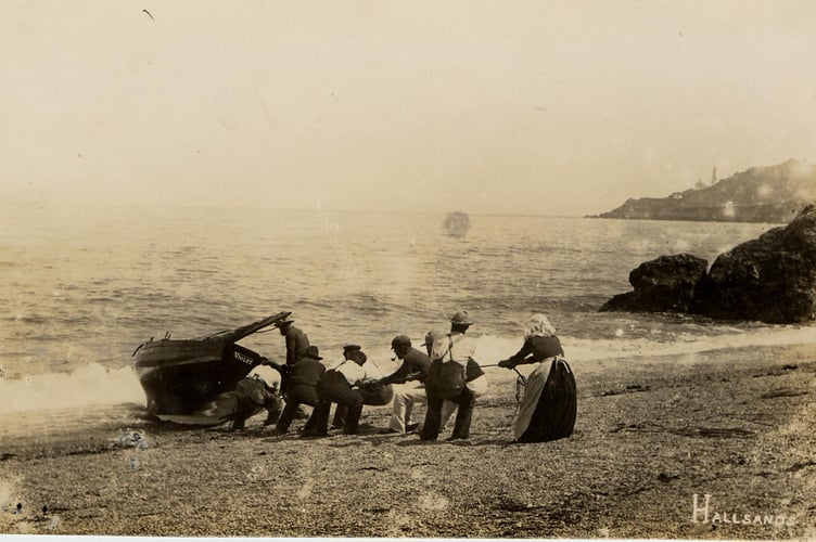1900 Men and women hauling fishing boat ‘Violet’ onto Hallsands beach.