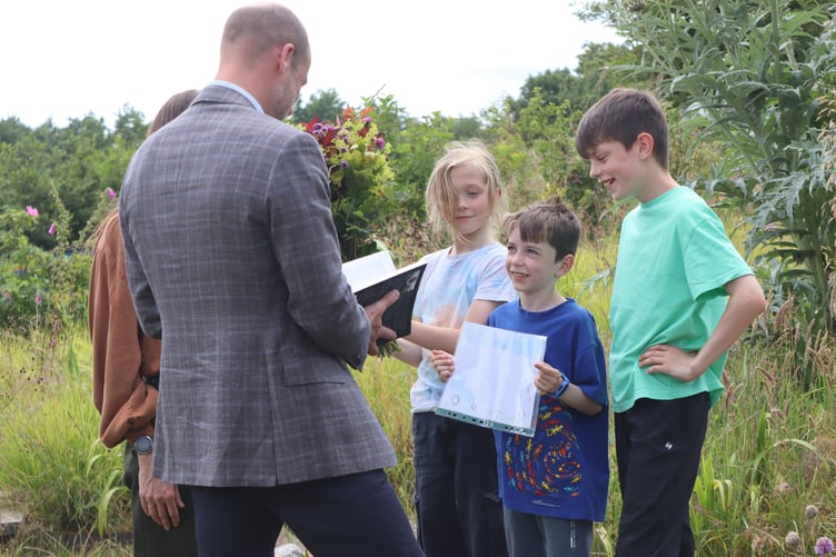 HRH receiving gifts from the children in the wellbeing garden